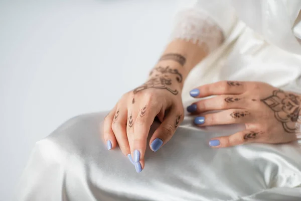 Vista recortada de la mujer joven con mehndi en blanco - foto de stock