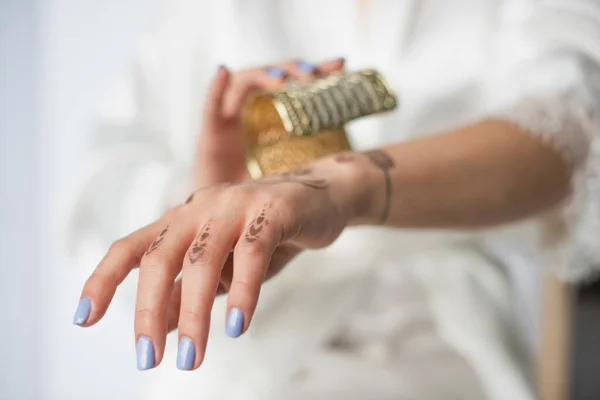 Cropped view of young indian woman with mehndi on hand wearing bracelet on white — Stock Photo