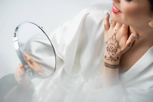 Vue partielle de la mariée indienne floue et heureuse regardant miroir isolé sur blanc — Photo de stock
