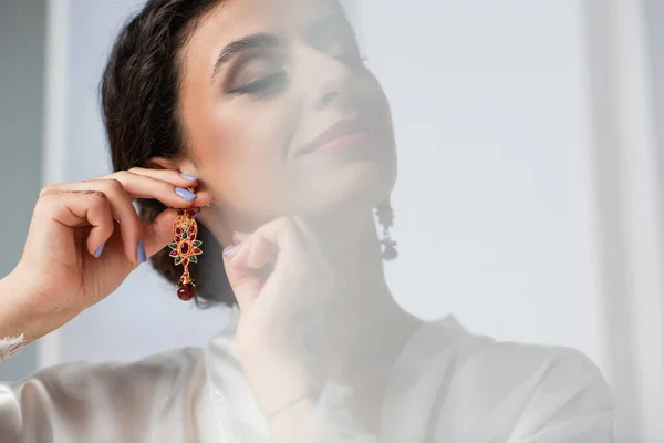 Young indian bride wearing earring on white — Stock Photo