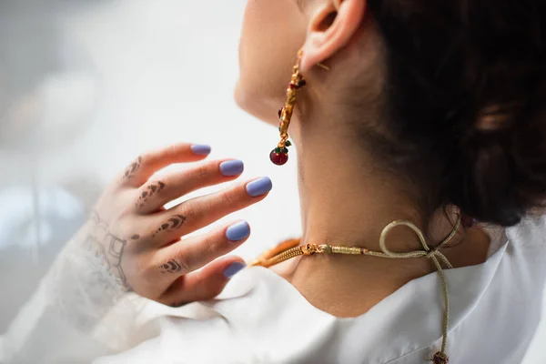 Vue arrière de la jeune mariée indienne en boucle d'oreille portant un collier sur blanc — Photo de stock