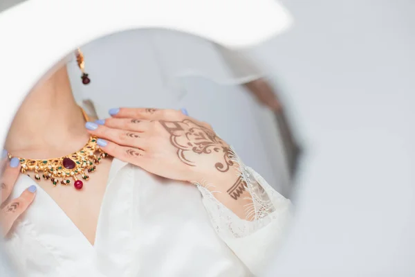 Reflexion im Spiegel der jungen indischen Braut in Ohrring, Halskette auf weißem Grund — Stockfoto