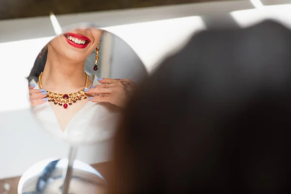 Cropped view of happy indian bride wearing necklace near mirror — Stock Photo