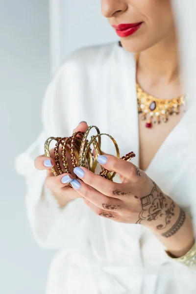 Partial view of young indian bride with mehndi holding bracelets — Stock Photo