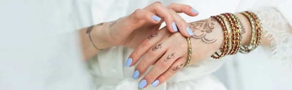 Cropped view of young indian bride with mehndi wearing bracelets, banner — Stock Photo