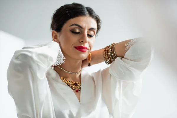 Mariée indienne avec les yeux fermés portant collier sur blanc — Photo de stock