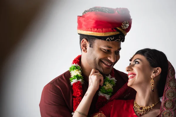 Heureux couple indien de mari et femme en vêtements traditionnels se regardant sur blanc — Photo de stock