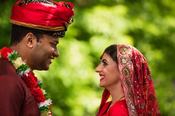 Side view of happy indian bridegroom and bride looking at each other — Stock Photo