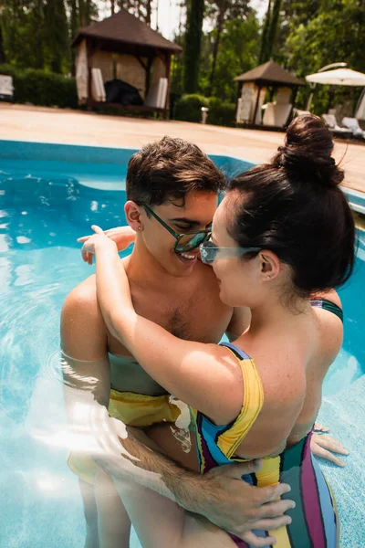 Felice uomo abbracciare fidanzata in piscina — Foto stock