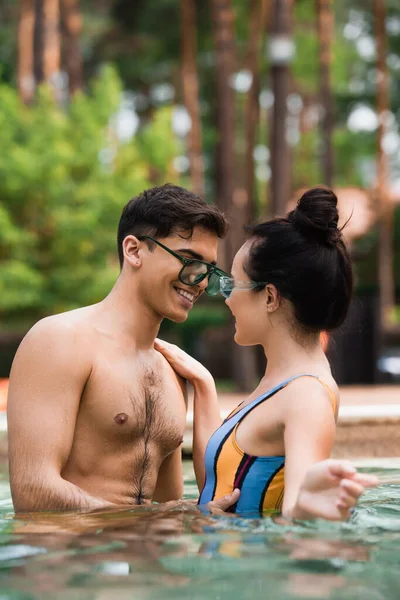 Jovem casal sorrindo na piscina durante o fim de semana — Fotografia de Stock