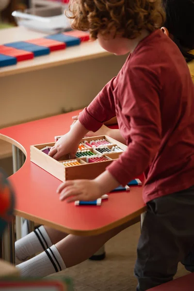 Partial view of boy playing cognitive game near girl in montessori school — Stock Photo