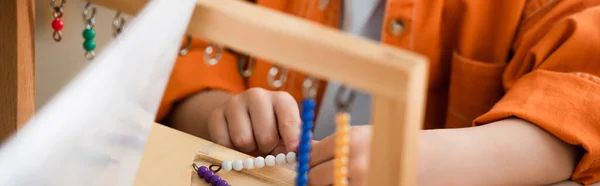 Vue recadrée d'un garçon jouant à un jeu éducatif à l'école montessori, bannière — Photo de stock