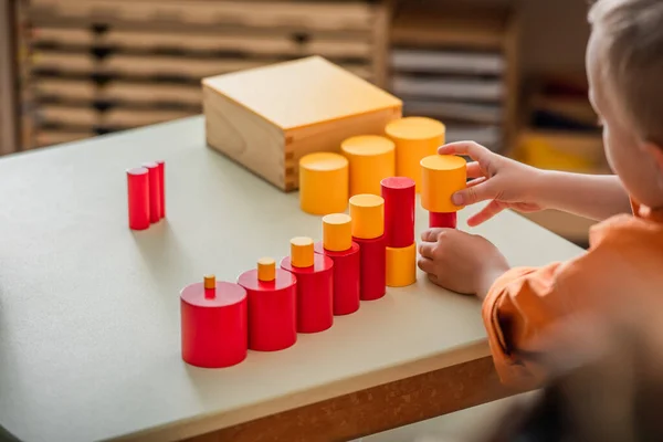 Vista parziale del bambino che gioca con i blocchi rossi e gialli nella scuola montessori — Foto stock