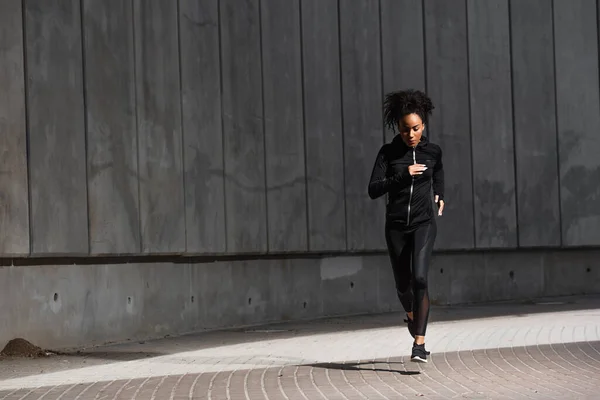 African american woman jogging on urban street — Stock Photo