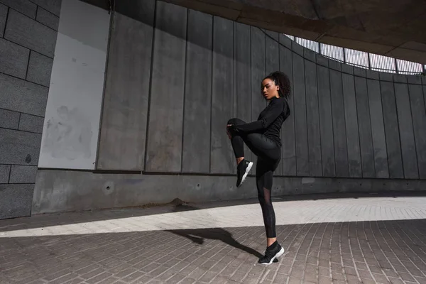 Deportista afroamericana haciendo ejercicio en la calle urbana - foto de stock