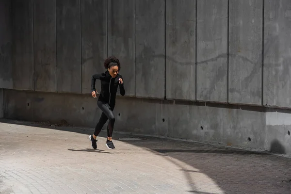 African american runner exercising near building outdoors — Stock Photo