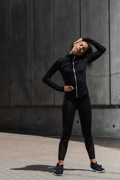 African american sportswoman stretching before work out outdoors — Stock Photo