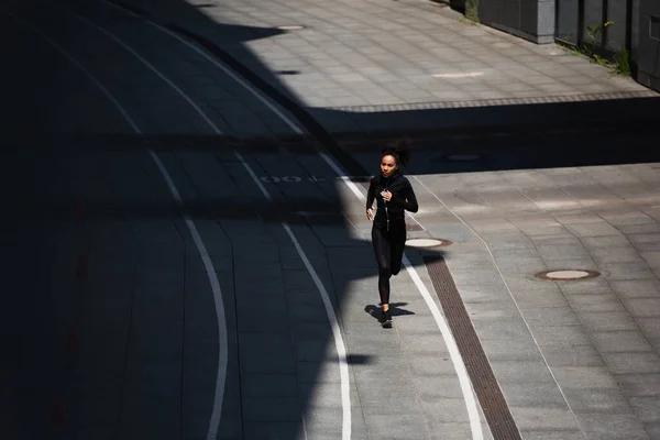 Високий кут Вид на афроамериканську спортсменку біжить по вулиці — стокове фото
