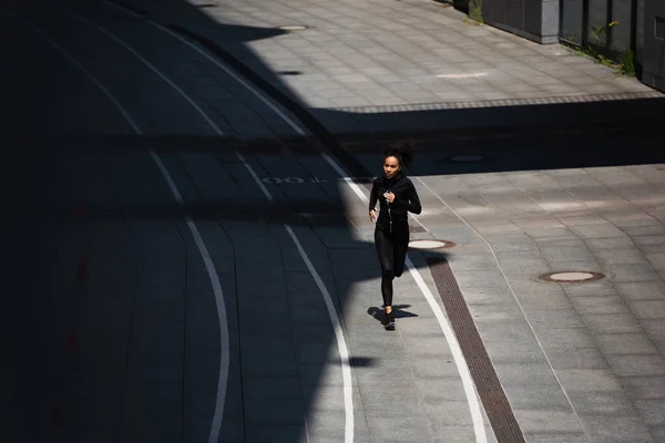 Vista ad alto angolo della sportiva afro-americana che corre in pista all'aperto — Foto stock