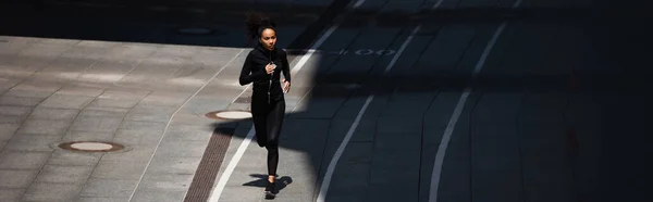 Afroamerikanische Sportlerin läuft auf Bahn, Banner — Stockfoto