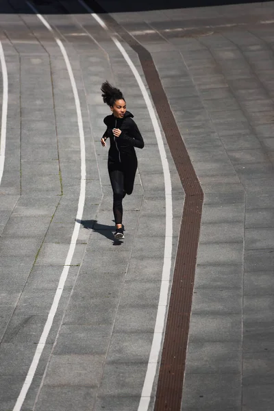 Афроамериканська спортсменка біжить по вулиці. — стокове фото