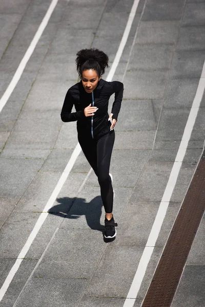 Високий кут зору афроамериканських тренувань бігунів на треку на відкритому повітрі — стокове фото