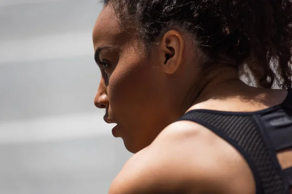 Seitenansicht einer afrikanisch-amerikanischen Sportlerin, die wegschaut — Stockfoto
