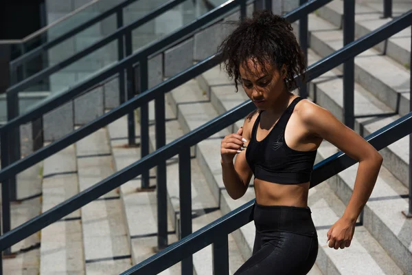 African american runner in top training on stairs near railing — Stock Photo