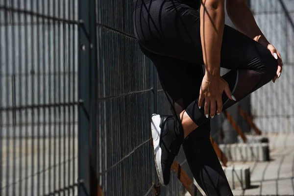 Vista ritagliata della sportiva afro-americana in piedi vicino alla recinzione — Foto stock