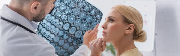 Mujer preocupada mirando al doctor sosteniendo cerebro mri scan, banner — Stock Photo