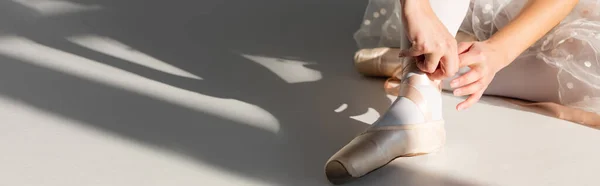 Vista recortada de la bailarina con zapato de punta sobre fondo gris, pancarta - foto de stock