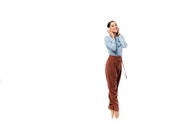 Bailarina sonriente en auriculares mirando a la cámara aislada en blanco - foto de stock