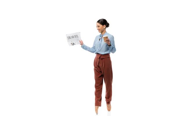 Ballerine souriante tenant journal et tasse en papier sur fond blanc — Photo de stock