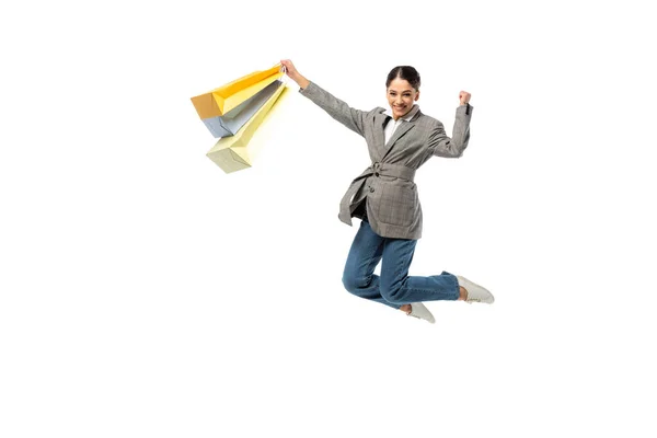 Cheerful woman with shopping bags showing yes gesture isolated on white — Stock Photo