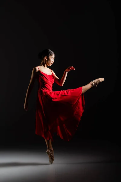 Seitenansicht der Ballerina, die auf schwarzem Hintergrund tanzt — Stockfoto