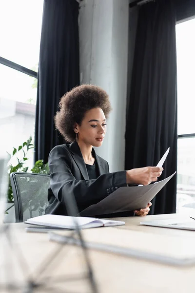 Jeune femme d'affaires afro-américaine travaillant avec des documents sur le lieu de travail — Photo de stock