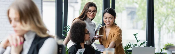 Junge multiethnische Geschäftsfrauen, die gemeinsam im Büro arbeiten, Banner — Stockfoto