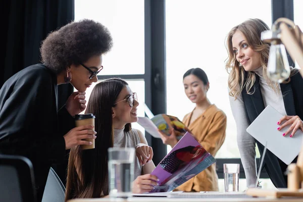 Donne d'affari multietniche che leggono riviste in carica durante la pausa caffè — Foto stock