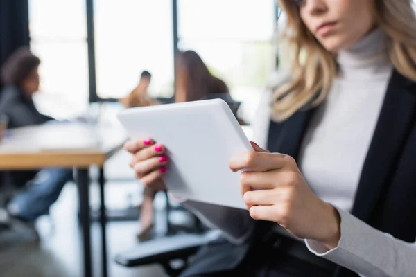 Vista recortada de empresaria borrosa sosteniendo tableta digital en la oficina — Stock Photo