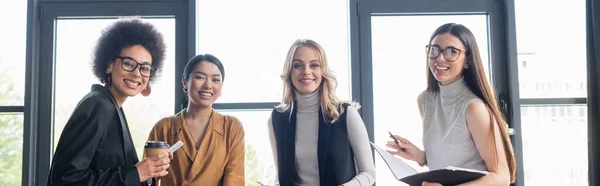 Fröhliche multiethnische Manager, die in der Kaffeepause in die Kamera blicken, Banner — Stockfoto