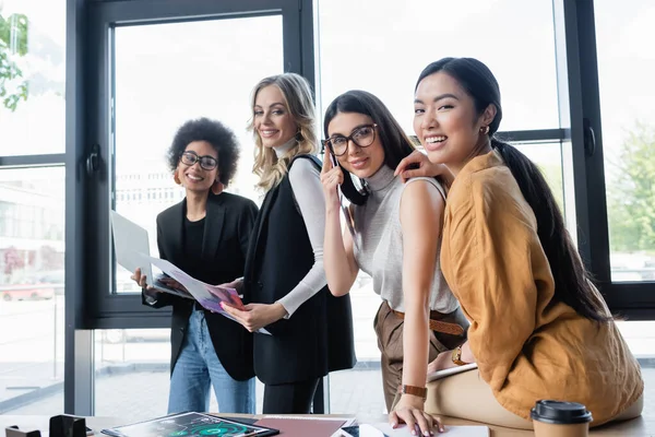 Hübsche und gut gelaunte Geschäftsfrauen blicken in der Kaffeepause in die Kamera — Stockfoto