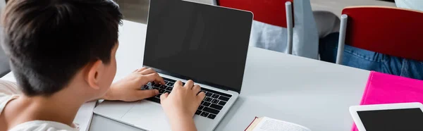 High angle view of boy using laptop in classroom, banner — Stock Photo