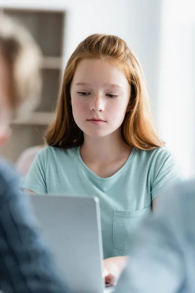 Підліток школярка використовує розмитий ноутбук в класі — стокове фото