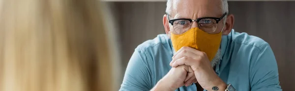 Reifer Lehrer in Schutzmaske blickt verschwommene Pupille an, Banner — Stockfoto