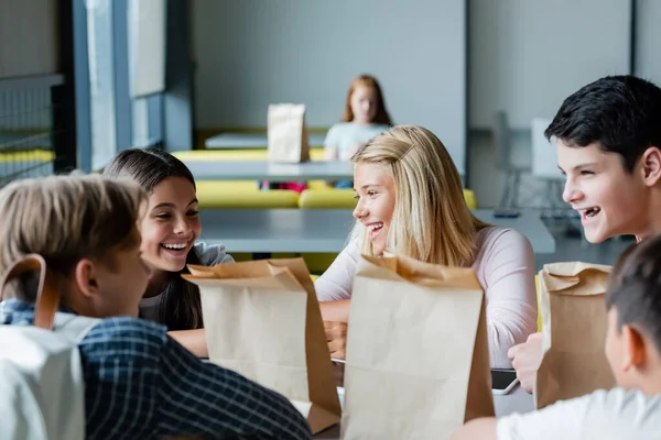 Felici adolescenti parlando a scuola ristorante mentre depresso ragazza seduta da sola su sfondo sfocato — Foto stock