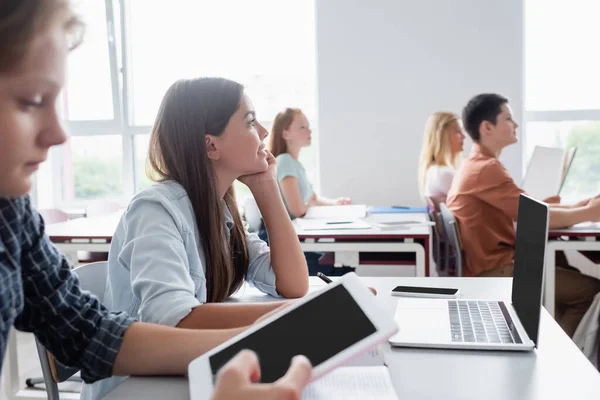 Verschwommener Junge nutzt digitales Tablet in der Nähe von Klassenkameraden während des Unterrichts — Stockfoto