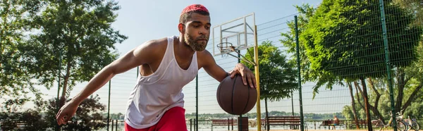 Junger afrikanisch-amerikanischer Mann spielt Basketball im Freien, Banner — Stockfoto