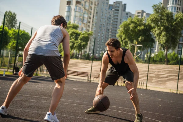 Giovani amici che giocano a basket nel parco giochi all'aperto — Foto stock