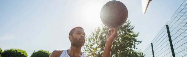 Uomo afroamericano che tiene palla da basket all'aperto, striscione — Foto stock