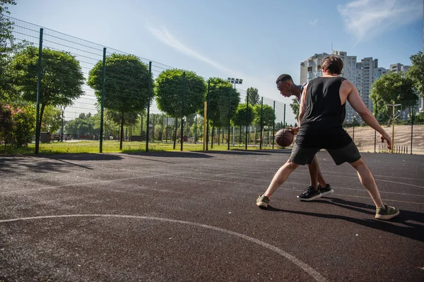 Allenamento di sportivi interrazziali mentre giocano a basket all'aperto — Foto stock